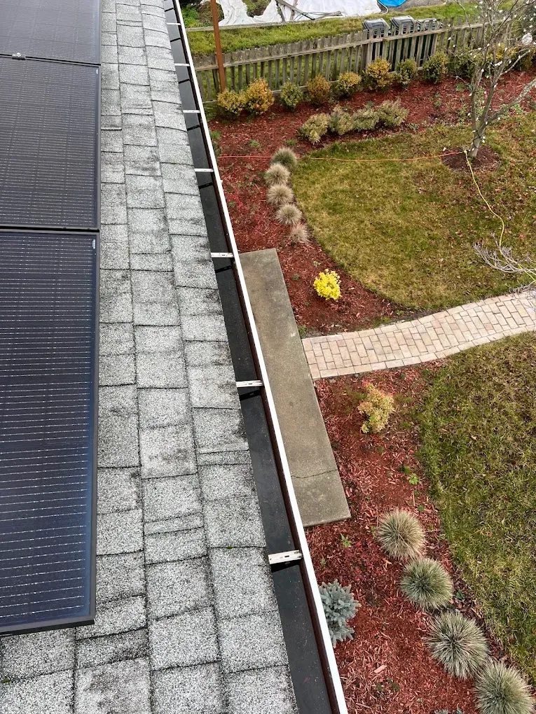 Sighting along a gutter run from the roof to check it drains toward the outlet