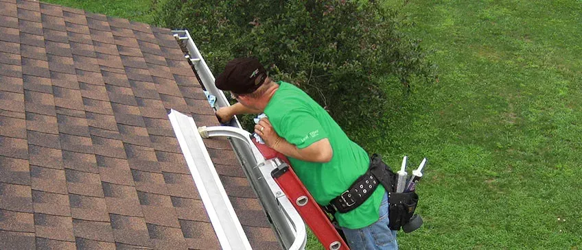 Working along a gutter at the roof edge from a ladder